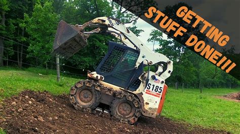 spreading topsoil with skid steer|Skid Steer placing rubble, loading and spreading topsoil .